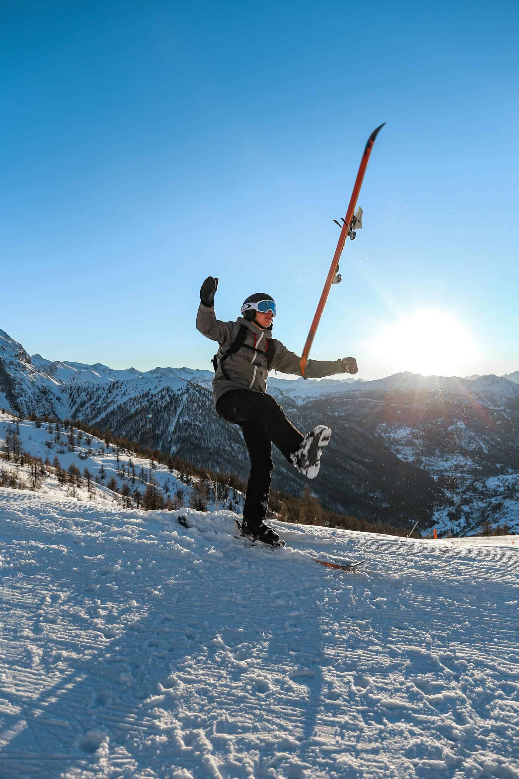 A skier celebrates on a snowy mountain at sunrise, capturing the essence of winter adventure.